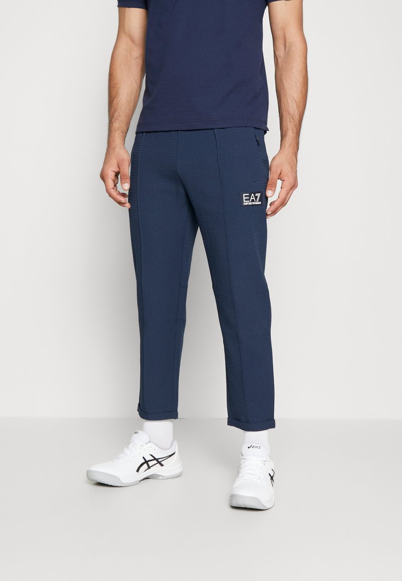 Men’s Long trousers | EA7 Emporio Armani TENNIS CLUB PANTS LIGHT – Tracksuit bottoms – navy blue/dark blue – LO16273